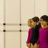Aurora, Angelica e Aurora, tre delle iscritte al corso intermedio riservato alle bambine tra i 5 e i 7 anni. Sulla destra si intravede la sbarra usata per lo stretching all'inizio degli allenamenti

